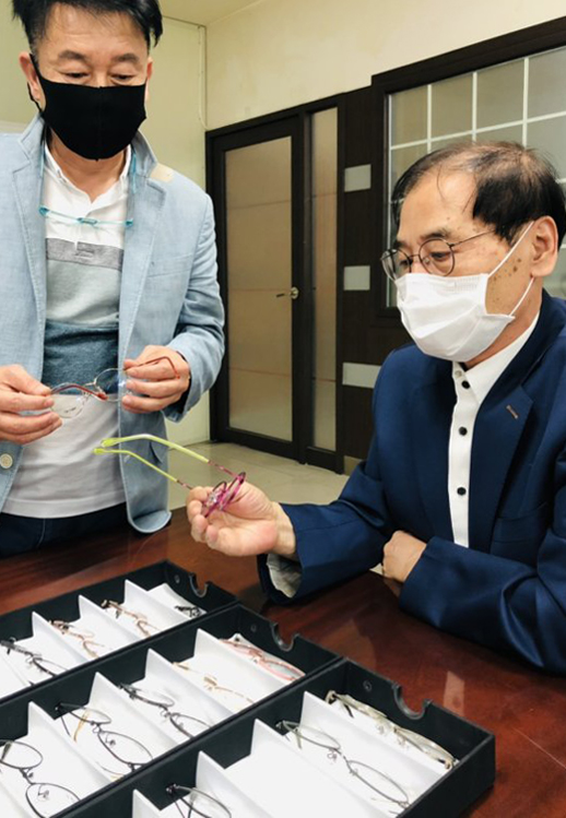 박재은(오른쪽) 로고스텍 대표가 황규한 SEE1 대표와 100% 순수 국산 항균 안경인 '레진 아트'를 살펴보며 대화를 나누고  있다.  /사진=로고스텍 제공
