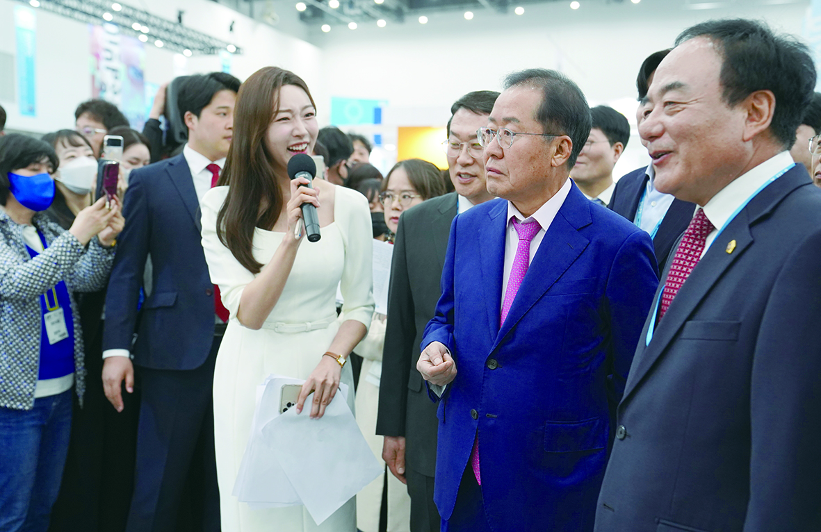 홍준표 대구시장이 대구국제안경전 한 부스에서 진행자 설명을 듣고 있다.