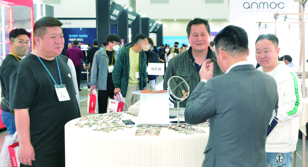 제이에스아이웨어 부스에서 참관객들이 제품을 써보며 설명을 듣고 있다.