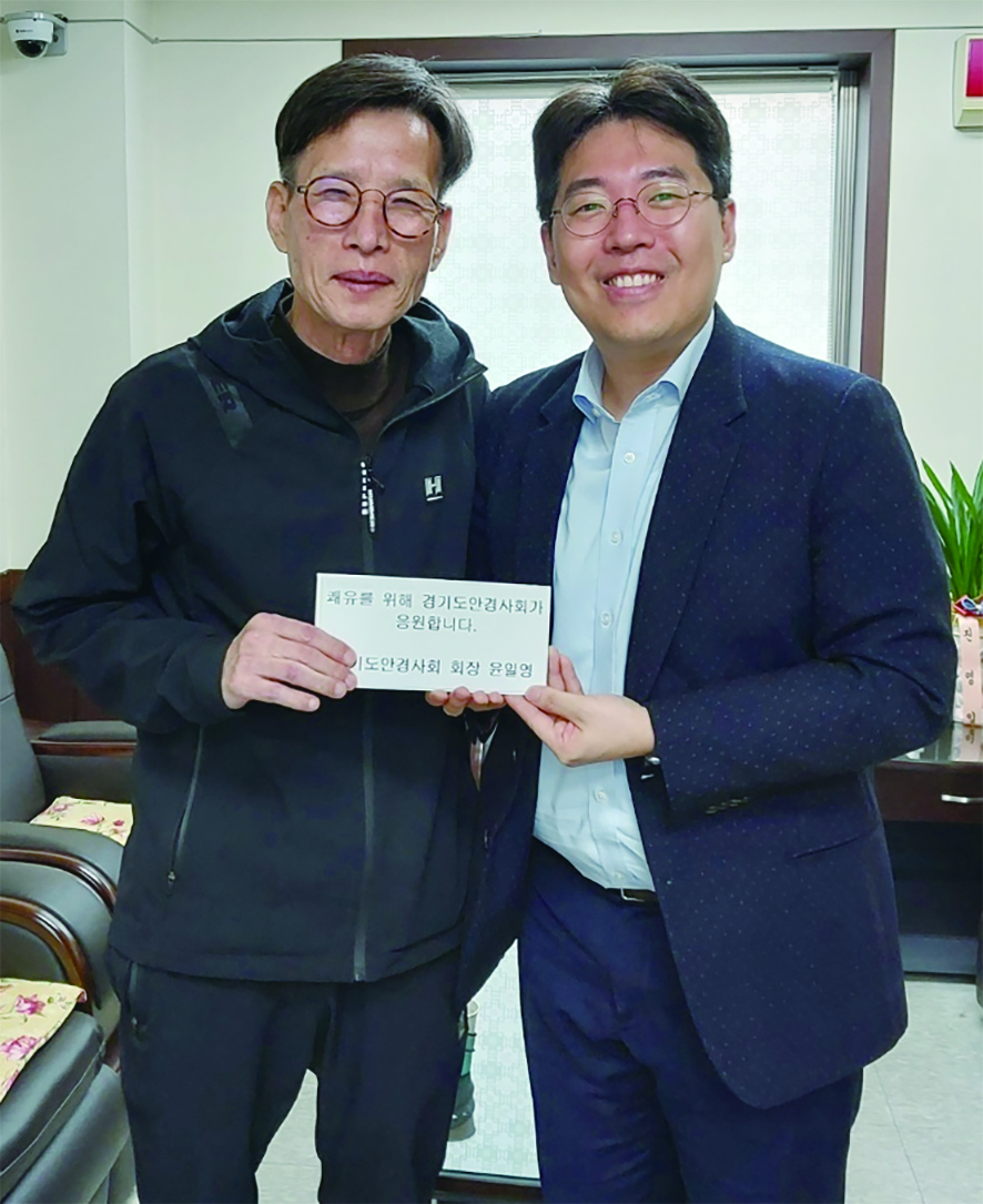 경기도안경사회 윤일영 회장(오른쪽)이 심태환 안경사에게 회복지원금을 전달하며 기념촬영을 하고 있다. 